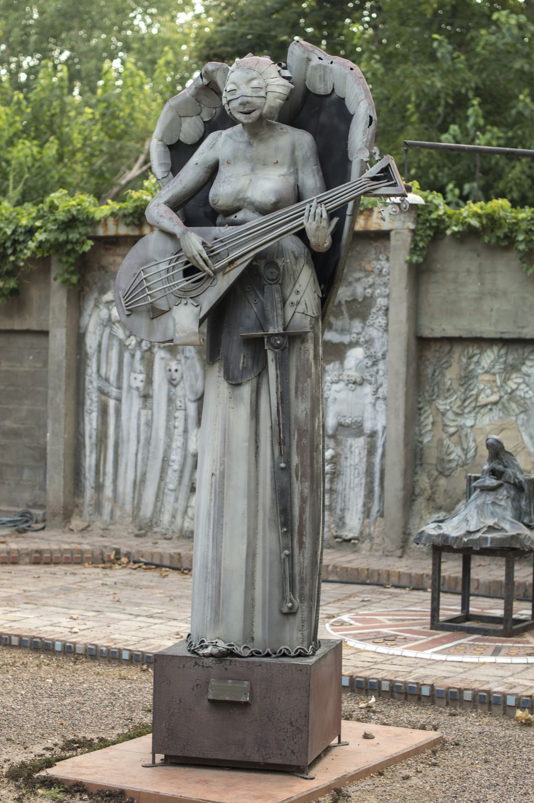 Patio de los Colosos, ángel alado tocando un instrumento de cuerdas